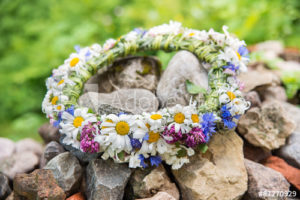 flower wreath lying on rocks in midsummer