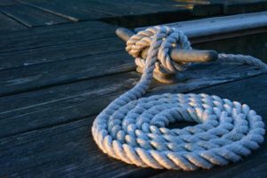 rope coiled on a dock and tied to the wharf