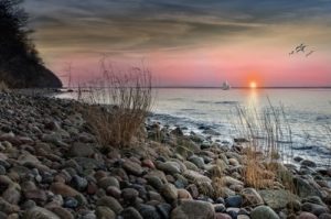 coastline at sunset with a boat in the distance