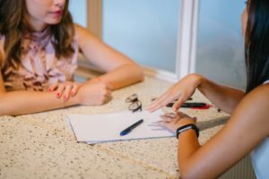 What Do Professional Genealogists Do, two women sitting at a desk talking