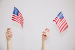 4 easy steps to join a lineage society, www.savvygenealogy.com, children's hands holding small American flags on white background